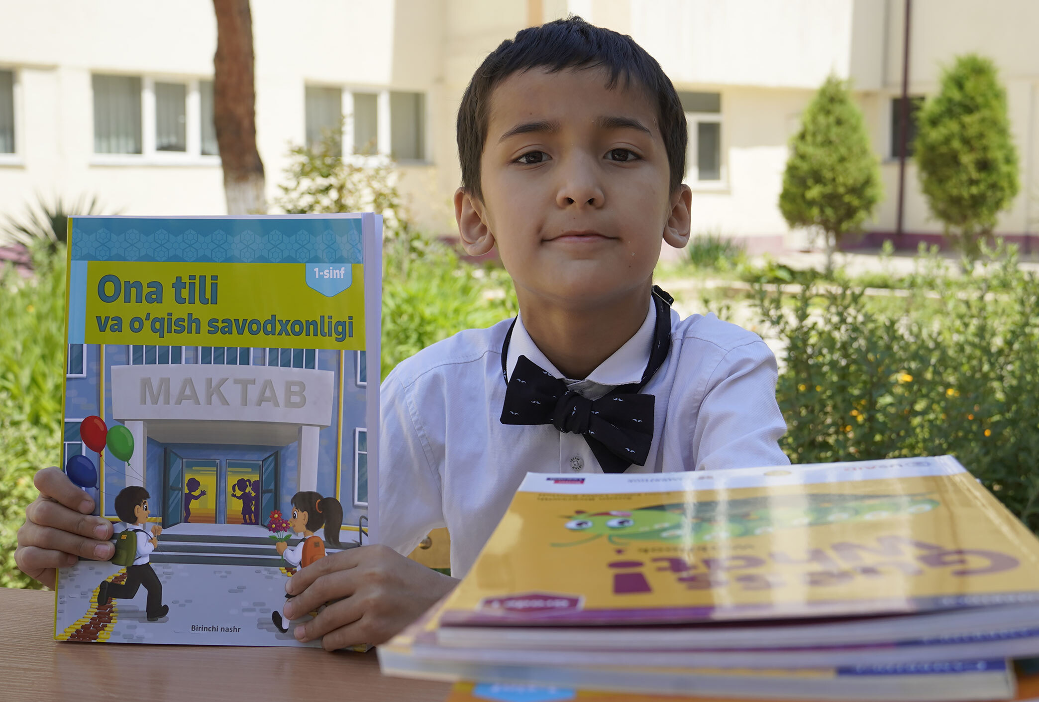 An Uzbek student showcasing a school book.